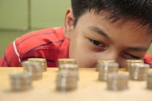 A boy examines stacks of coins